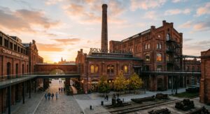 A professional editorial-style photograph showcasing the atmospheric red-brick industrial architectu