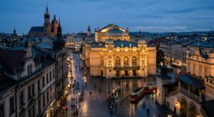 A high-angle, editorial-style photograph of the illuminated Juliusz Słowacki Theatre in Kraków at tw